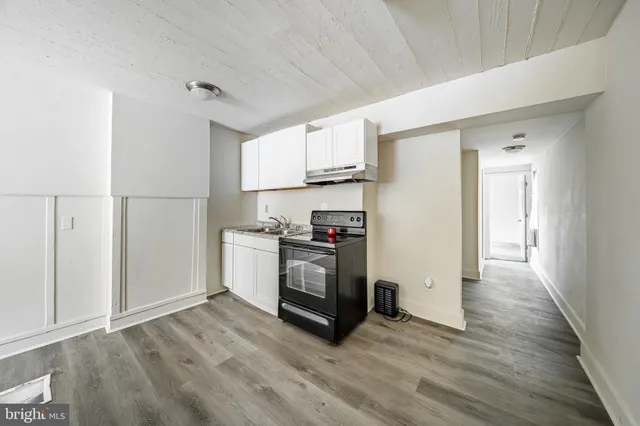 a kitchen with granite countertop a refrigerator and a stove top oven