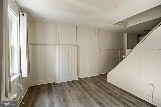 a view of a room with wooden floor and white walls