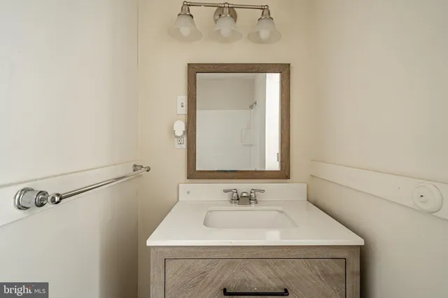 a bathroom with a sink vanity and a mirror