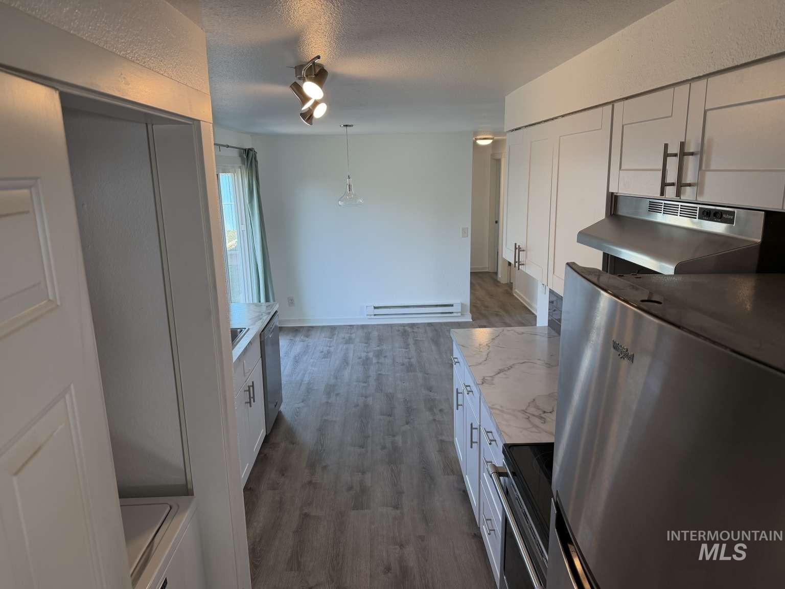 211 Jasper Avenue Middleton, ID 83644 - Photo 16 of 25 Kitchen featuring stainless steel appliances, white cabinets, extractor fan, a textured ceiling, and decorative light fixtures