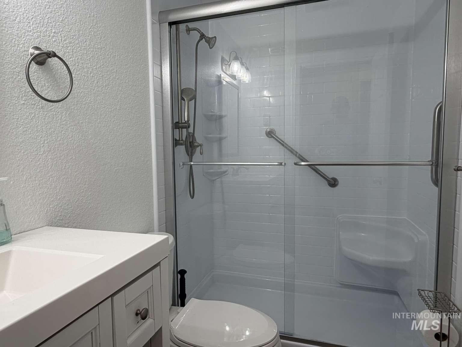 211 Jasper Avenue Middleton, ID 83644 - Photo 21 of 25 Full bath featuring a textured wall, vanity, and a stall shower