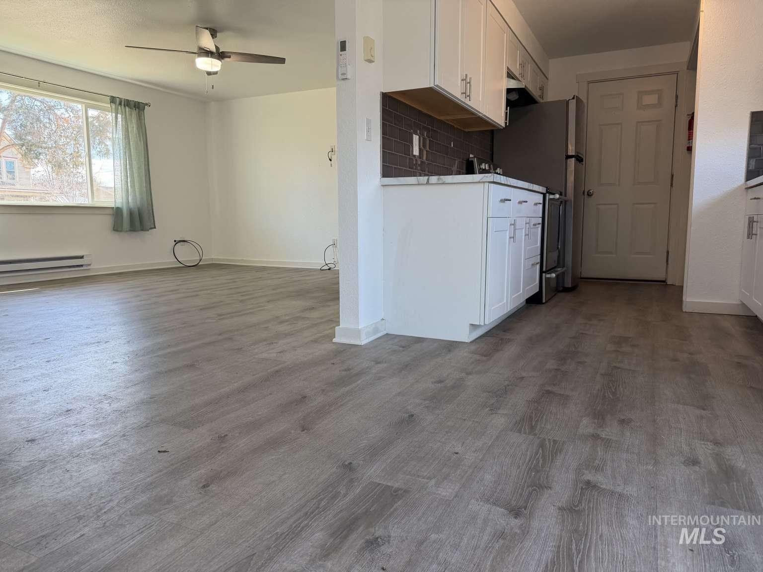 211 Jasper Avenue Middleton, ID 83644 - Photo 25 of 25 Kitchen with white cabinetry, a ceiling fan, open floor plan, light countertops, and dark wood-style floors