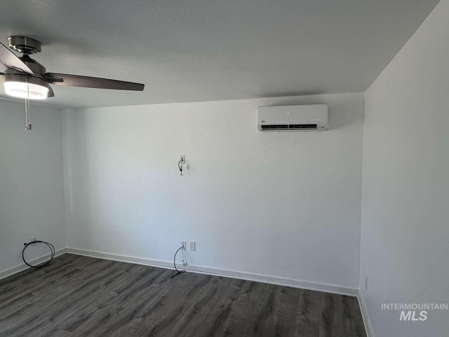 211 Jasper Avenue Middleton, ID 83644 - Photo 24 of 25 Empty room featuring dark wood-type flooring, a wall mounted mini split, and a ceiling fan