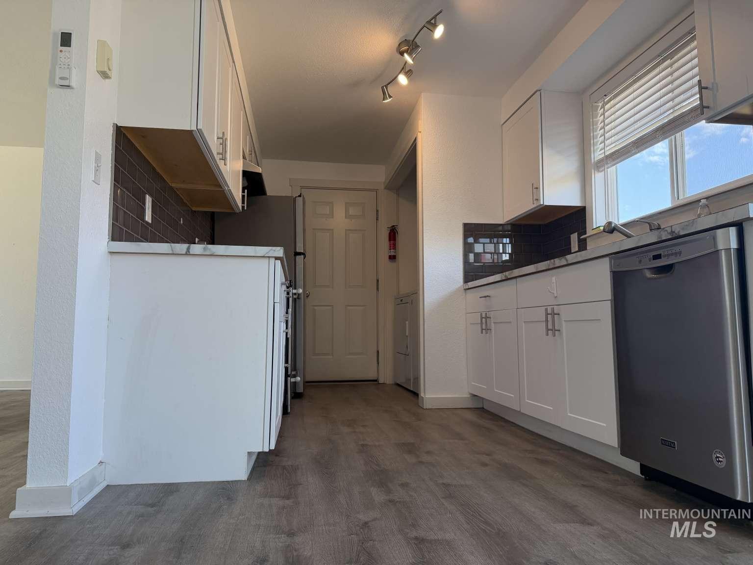 211 Jasper Avenue Middleton, ID 83644 - Photo 8 of 25 Kitchen with white cabinets, dishwasher, light countertops, dark wood finished floors, and a textured wall