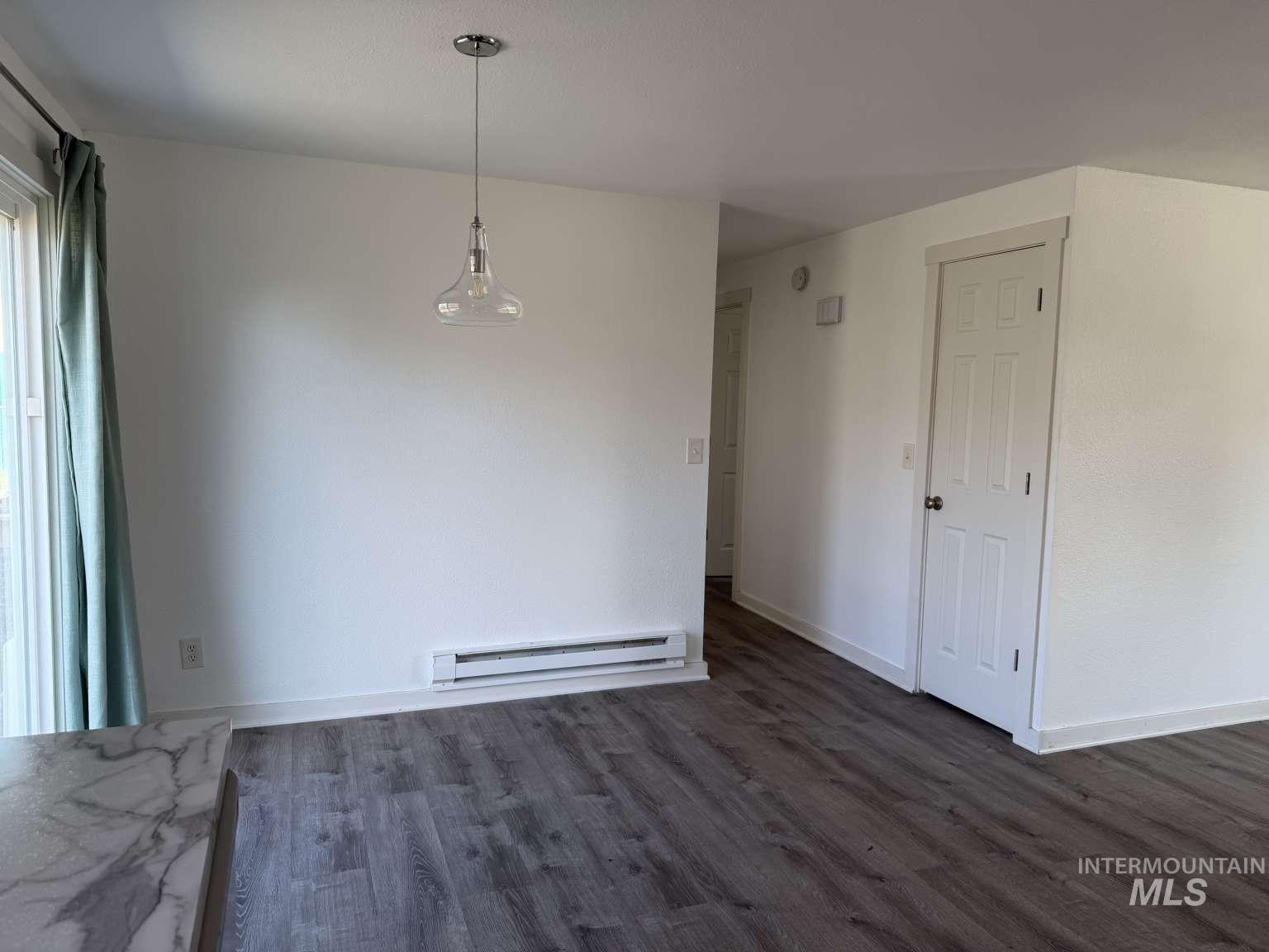 211 Jasper Avenue Middleton, ID 83644 - Photo 9 of 25 Unfurnished dining area featuring dark wood-style floors and baseboard heating