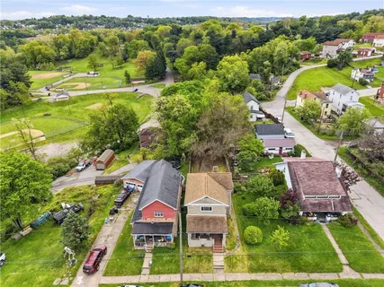 an aerial view of residential houses with outdoor space and swimming pool