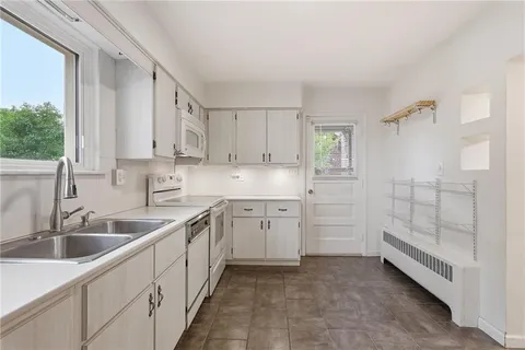a kitchen with white cabinets and sink