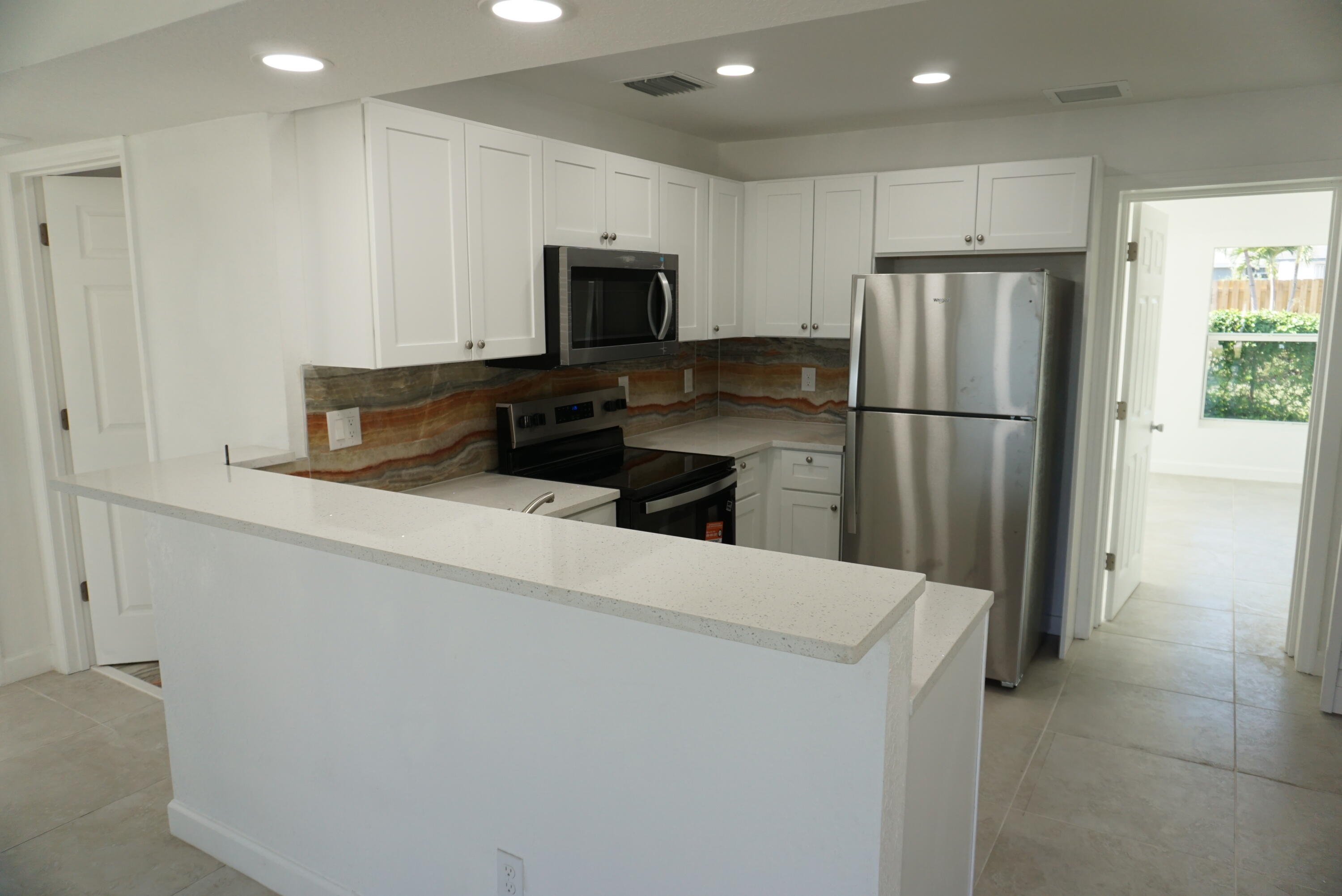 a kitchen with a refrigerator a microwave and sink