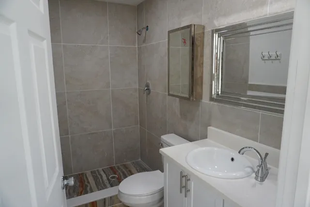 a bathroom with a sink a toilet and shower