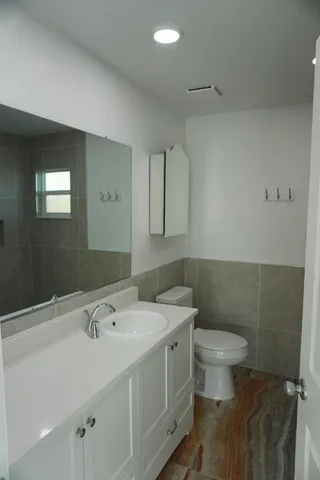 a bathroom with a sink toilet and mirror