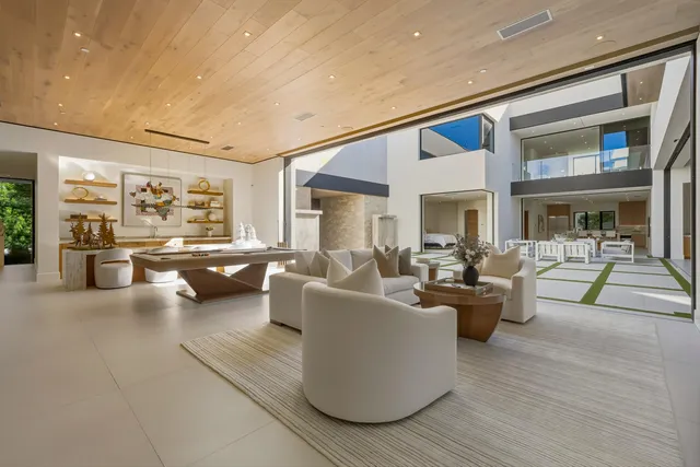 a living room with fireplace furniture and a large window