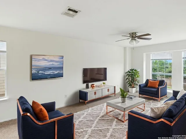 a living room with furniture a window and a flat screen tv