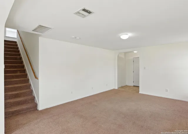 a view of an empty room with stairs