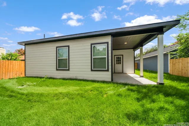 a view of a backyard with potted plants and a large tree