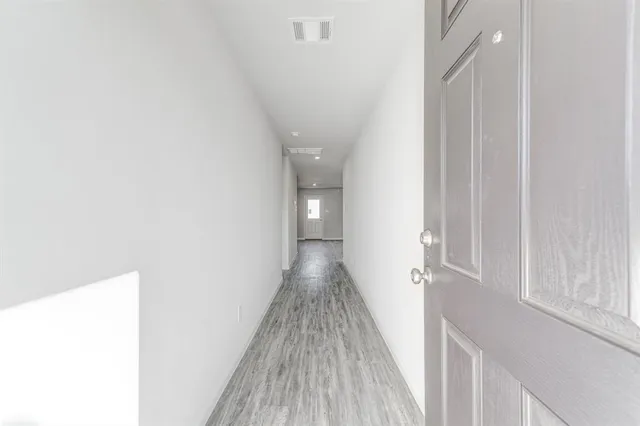a view of a hallway with wooden floor