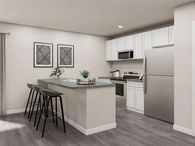 a kitchen with a sink a refrigerator a microwave and cabinets