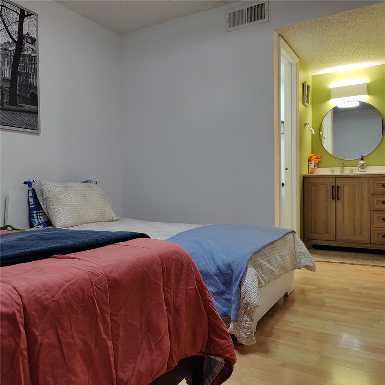 18333 Roehampton Drive Dallas, TX 75252 - Photo 7 of 10 a bedroom with a bed and painting on the wall