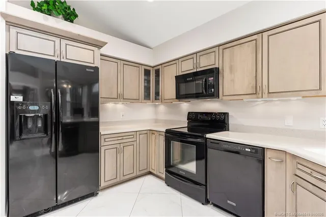 a kitchen with stainless steel appliances granite countertop a refrigerator a stove a sink and dishwasher with wooden floor