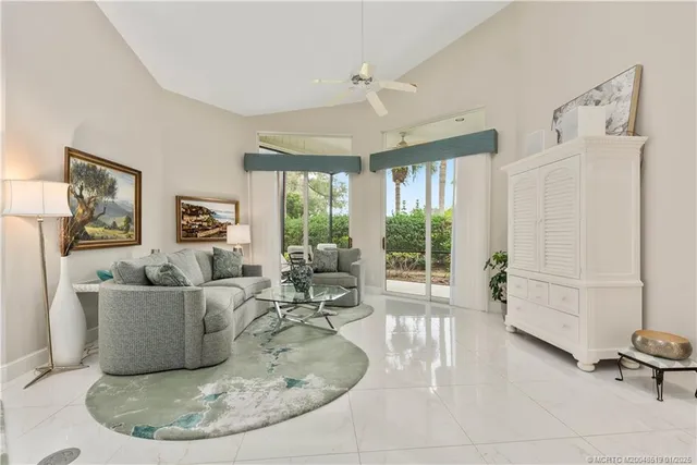 a living room with furniture large window and wooden floor
