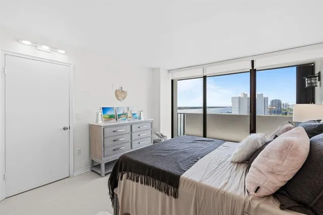 a bedroom with a bed and large window