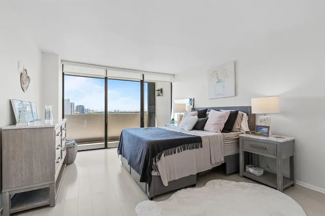 a bedroom with a bed and large window