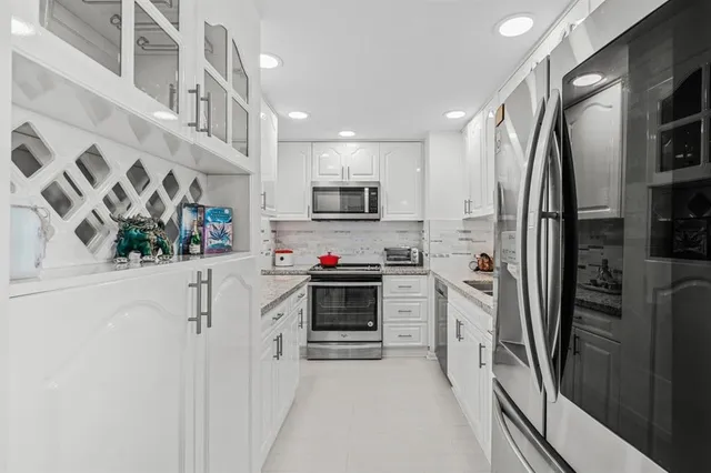 a kitchen with stainless steel appliances white cabinets and a refrigerator