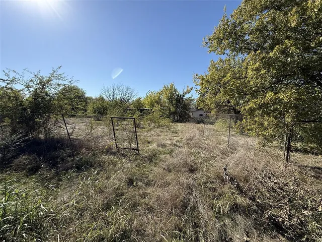a view of a field with trees in the background