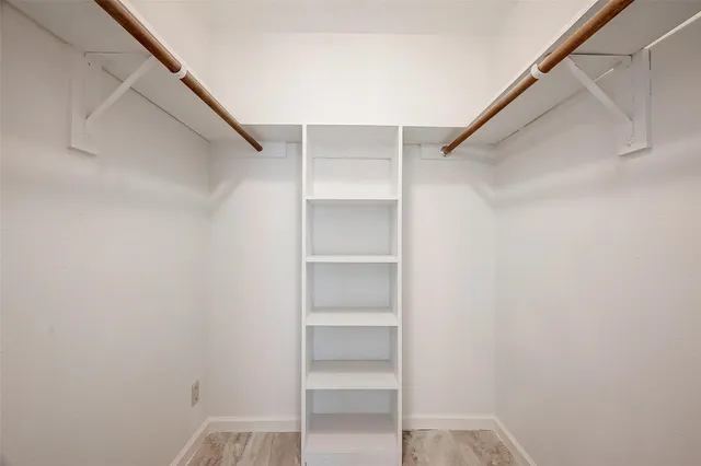 a view of walk in closet with empty racks