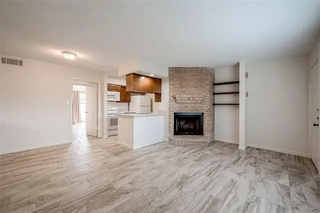 a view of kitchen and empty room with wooden floor