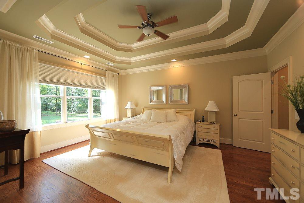 1809 Silver Mist Court Raleigh, NC 27613 - Photo 22 of 30 a spacious bedroom with a bed and wooden floor