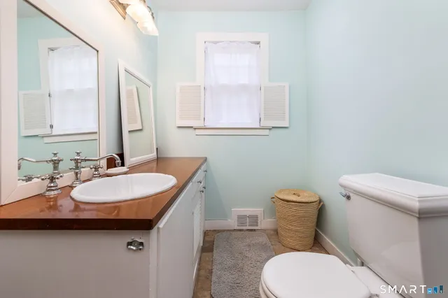 a bathroom with a sink toilet and mirror