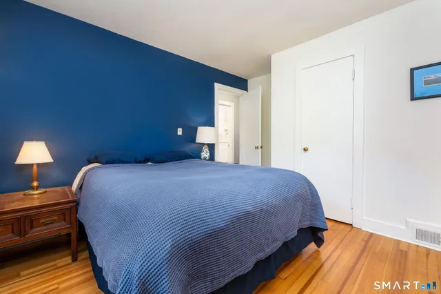 a bedroom with a bed and wooden floor