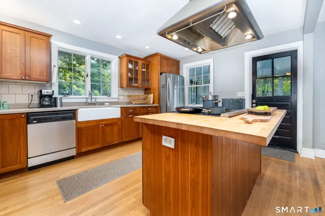 a kitchen with stainless steel appliances granite countertop a sink a stove and a refrigerator