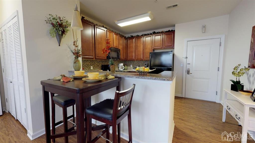 4208 Pine Valley Way Piscataway, NJ 08854 - Photo 19 of 26 a kitchen with a table chairs refrigerator and microwave