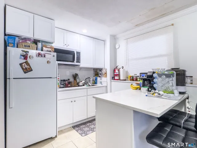 a kitchen with a sink a stove and white cabinets