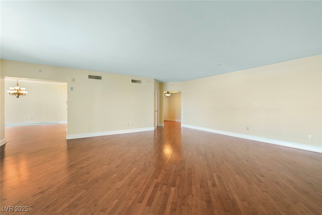 2857 Paradise Road, Unit 802 Las Vegas, NV 89109 - Photo 5 of 36 Unfurnished room with a chandelier, hardwood / wood-style flooring, and baseboards