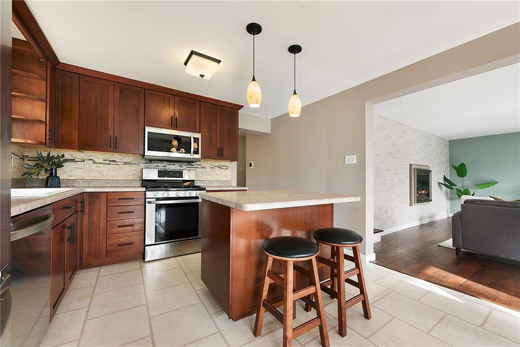 6913 Merton Road Pittsburgh, PA 15202 - Photo 19 of 48 a kitchen with kitchen island granite countertop wooden cabinets and stainless steel appliances