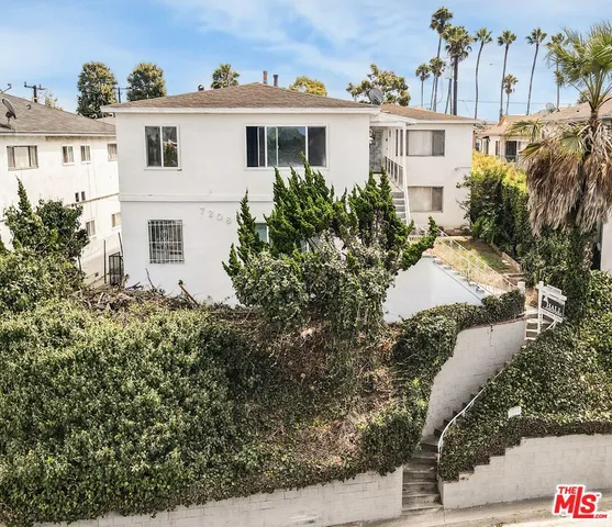 a view of a white house with a yard and plants