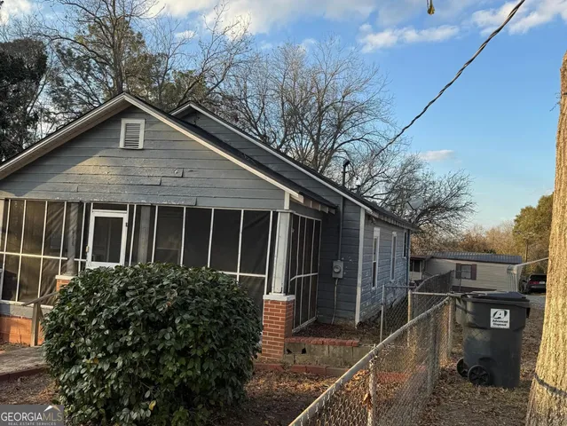 a view of a house with a small yard plants and large tree