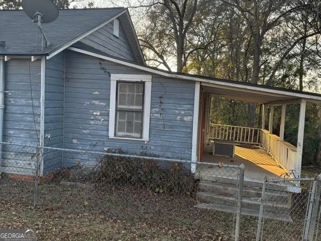a view of house with a yard and large tree