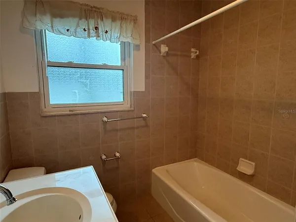 a bathroom with a sink a toilet and bathtub