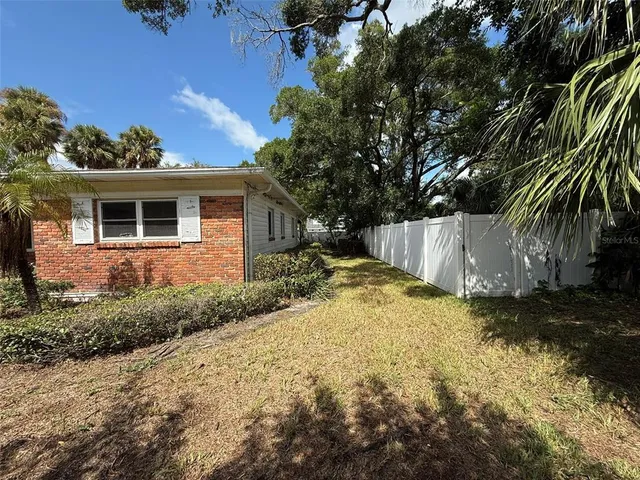 a view of a yard with plants and trees