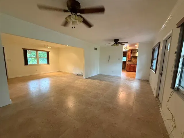 a view of a livingroom with a ceiling fan and window