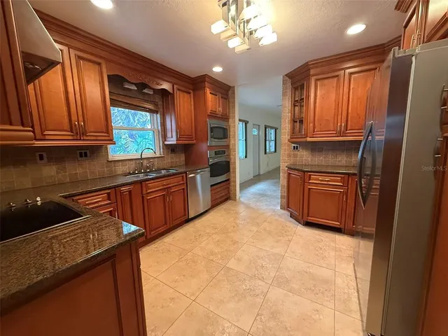 a kitchen with stainless steel appliances granite countertop a sink stove and refrigerator