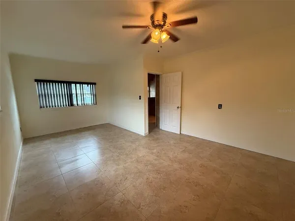 a view of a livingroom with a ceiling fan and window