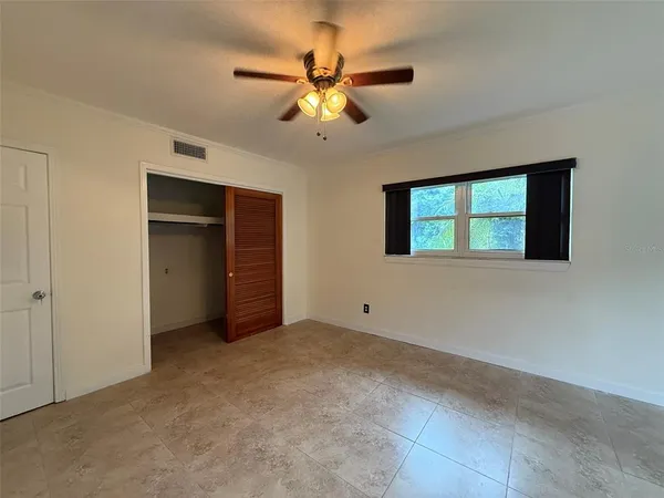 a view of an empty room with a ceiling fan