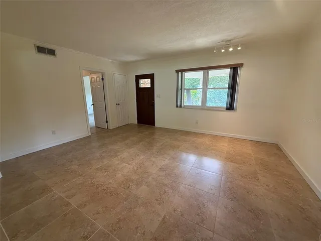an empty room with windows and closet