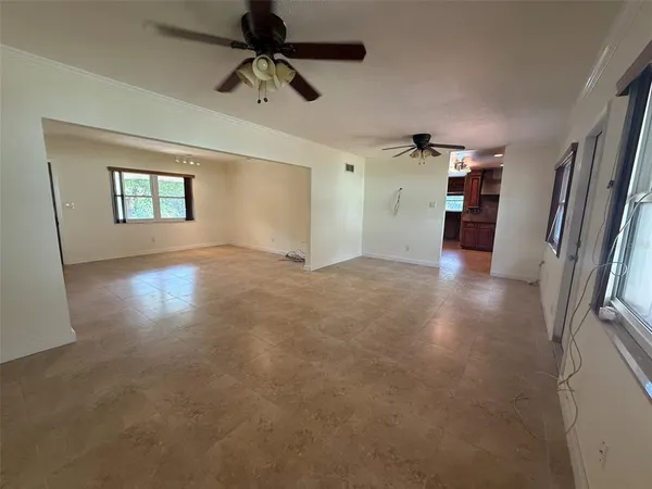 en empty room with windows and ceiling fan