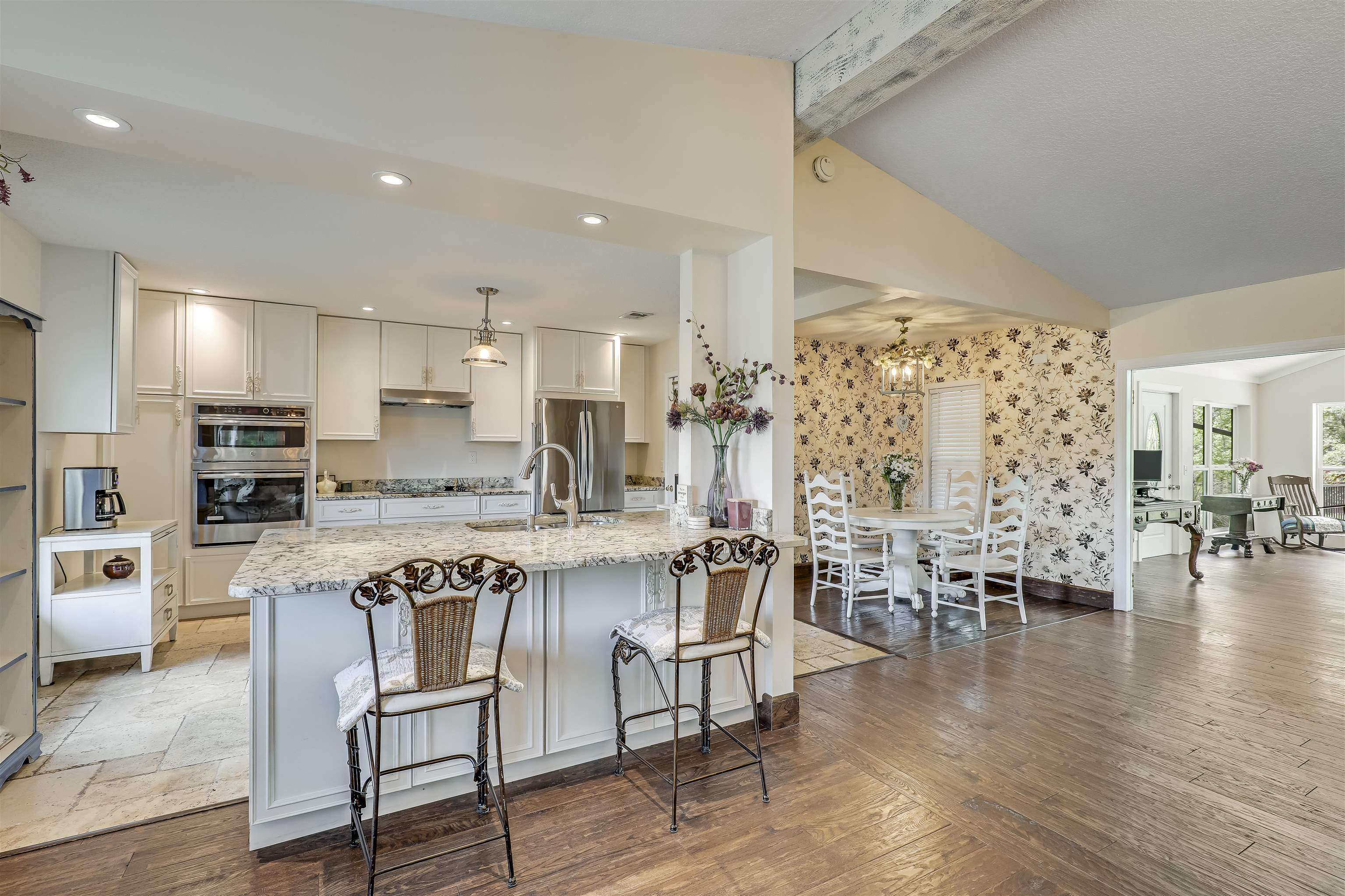 4485 Highway 16 St. Augustine, FL 32092 - Photo 18 of 59 a kitchen with stainless steel appliances a table chairs refrigerator and cabinets