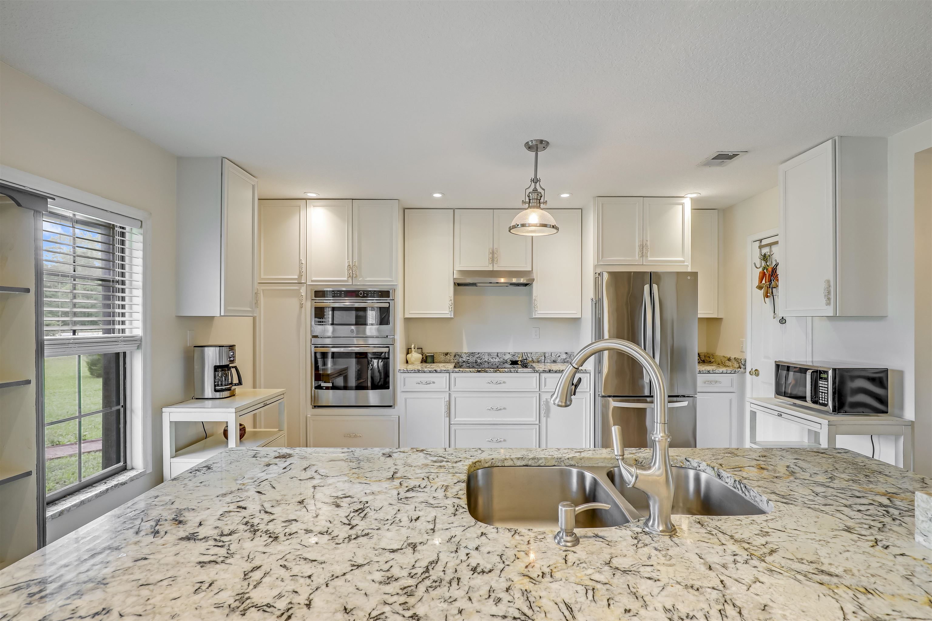 4485 Highway 16 St. Augustine, FL 32092 - Photo 19 of 59 a kitchen with stainless steel appliances kitchen island granite countertop a refrigerator and stove